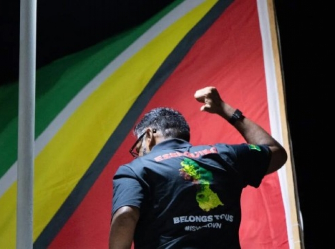 Presdident Irfaan Ali, points to his shirt which displays the message: Essequibo belongs to us.