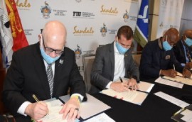 SRI’s executive chairman, Adam Stewart. (center) flanked by UWI Vice-Chancellor, Professor Sir Hilary Beckles (right) and FIU president, Dr. Mark B. Rosenberg, singing MOU.