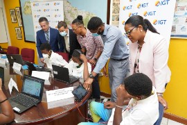 IGT After School Advantage (ASA) beneficiaries from the Sunbeam Children’s Home in Old Harbour, St. Catherine in Jamaica (seated) were accommodated on site at The University of the West Indies (UWI), Mona by the Mona Geoinformatics Institute (MGI) for the opening day of the 2022 IGT Coding and Robotics Rock! Camp on July 20. Standing (from left) are Juan Pablo Chadid, Regional Vice President of IGT Latin America and the Caribbean; Brendan Hames, Regional Director of IGT Caribbean; Kevin Johnson, Coordinator and Lead Tutor of MGI; Jordan Earle, Technical Support, MGI and Debbie Green, General Manager, IGT Jamaica.