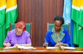 Minister of Parliamentary Affairs and Governance, Gail Teixeira and United Nations (UN) Resident Coordinator, Jean Kamau signing the agreement (DPI Photo)