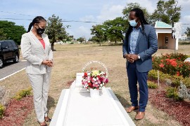 The Minister of State within the Ministry of Culture, Gender, Entertainment and Sport, the Hon Alando Terrelonge (right), and Acting Executive Director of the Jamaica Cultural Development Commission (JCDC) Marjorie Leyden-Kirton, stand by the tomb of Kenneth ‘Ken’ Hill, Jamaican political stalwart and trade unionist,during a wreath laying exercise in celebration of the 112th anniversary of his birth at the National Heroes Park in Kingston yesterday.