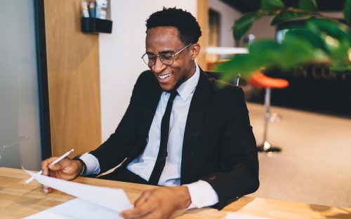 Cheerful African American employee working in modern office
