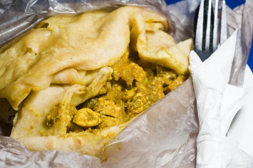 dahl pouri roti photographed in port of spain trinidad native food wrap also called bust up shot or dosti roti fast food with curried chicken pumpkin  potatoes and ground chick peas