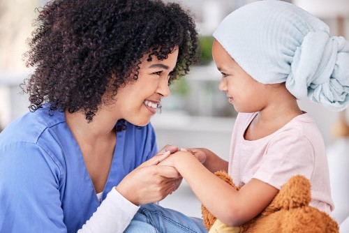 Smile, nurse and child on bed in hospital for children, health and medicine, support and trust in cancer treatment. Paediatrics, healthcare and kid, nursing caregiver holding hands with young patient