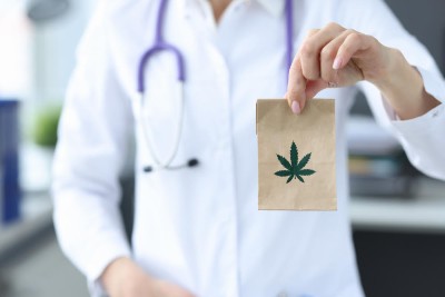Doctor holding package with marijuana in clinic closeup. Treatment of depression with narcotic drugs concept