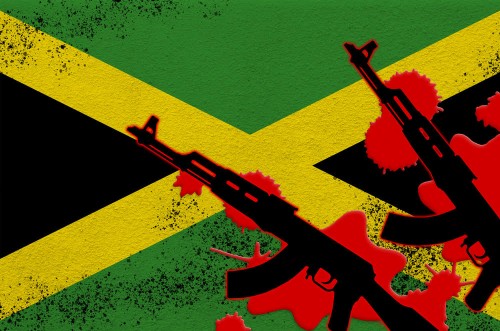 Jamaica flag and two black AK-47 rifles in red blood. Concept for terror attack or military operations with lethal outcome. Dangerous weapon usage