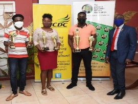 The top three winners of the 2020 Jamaica Customer Service Song competition (left to right) Yisrael Campbell representing Dobson Production the third place winner, Martanek Phipps representing the Marialites the second place winner, and Dannareo Fearon representing DF Productions the first place winner, pose with Richard Rowe, Deputy Chairman at the Jamaica Customer Service Association for a photo-op during the song competition’s award presentation on Friday, October 16, 2020 at the JCDC’s Head office in Kingston.