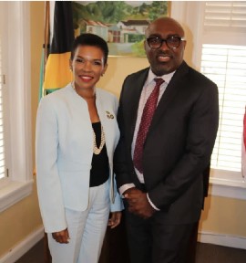 Jamaica’s Ambassador to Washington, Her Excellency Audrey Marks shears a light moment with Pumpstation Entertainment Manager Omar Stephenson of one organizer of the DC World Reggae Festival at its first launch at the embassy of Jamaica. (Photo by Derrick Scott)