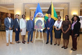 Jamaica’s outgoing Ambassador to the United States and Permanent Representative to the OAS, His Excellency Major General (Ret’d) Antony Anderson (fourth right), and OAS Secretary General Albert Ramdin (fourth left), pose with members of the Jamaican delegation following the unveiling of the portrait of Jamaican women’s rights pioneer Princess May Lawes in the Hall of Heroes and Heroines at OAS headquarters in Washington, D.C., on May 29, 2026. Also pictured, from left, are Mr. Emile Wallace-Waddell, Community Relations Officer at the Embassy of Jamaica; Mrs. Tanisha Ellison, Security Attaché at the Embassy of Jamaica; Mrs. Sharon Coburn Robinson, Principal Director in the Ministry of Culture, Gender, Entertainment and Sport; Ms. Delita McCallum, Jamaica’s Deputy Permanent Representative to the OAS; Ms. Brittany McCrea, Counsellor at the Embassy of Jamaica; and Ms. Mikella Richards, Fellow in the Office of the Prime Minister. (Photo by Derrick Scott)