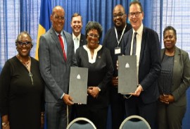 From left, Ambassador Elizabeth Thompson, Minister of Foreign Affairs Kerrie Symmonds, Prime Minister Mia Mottley, Minister in the Ministry of Economic Affairs and Investment Chad Blackman, UNIDO Director General Gerd Muller and other officials are all smiles following Tuesday’s signing. (Office of the Prime Minister Photo)