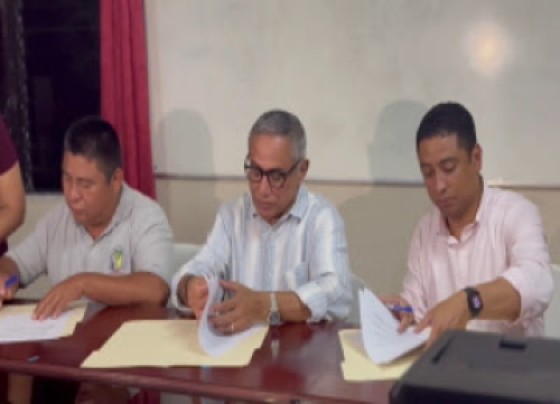 Prime Minister John Briceno (center) as stakeholders sign new agreement.