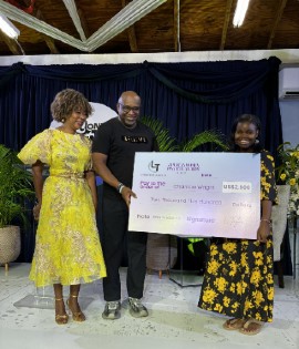 A beaming Chantae Wright (right) receives her scholarship check valued at US$2,500 from Lyndon Taylor, Founder and CEO, Lyndon Taylor & Associates. Looking on is Rev. Dr. Sheila McKeithen, President of the Universal Foundation for Better Living and Senior Minister, UCT Jamaica. (Photo credit: Sohail Powell)