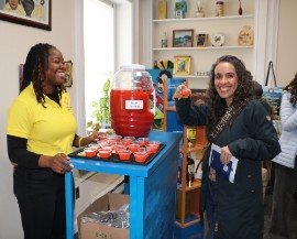 Patron to Passport DC at the Embassy of Jamaica, samples the Rum Punch one of the popular offerings served by embassy staff, Minister Counsellor for Trade Ms. Alicia Taylor, at the Passport DC’s annual “Around the World Embassy Tour”, held on Saturday, May 3, 2026. (Photo by Derrick Scott)