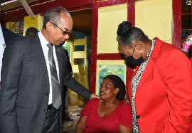 Deputy Prime Minister and National Security Minister, the Hon. Dr. Horace Chang (left) and Culture, Gender, Entertainment and Sport Minister, Hon. Olivia Grange (right) attempt to console bereaved mother and grandmother, Gwendolyn McKnight whose family was killed in the community of Chapelton, Clarendon in the early hours of Tuesday morning. (Photo credit: RUDRANATH FRASER via JIS)