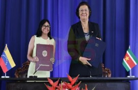 Venezuela’s Acting President Delcy Rodríguez and President Jennifer Geerlings-Simons show off the documents containing the bilateral agreements.