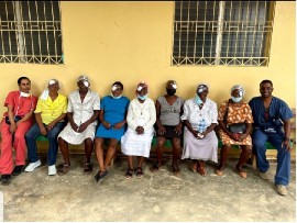 ACPNY’s Dr. Anika Michael and Dr. Benjeil Edghill sit with patients they cared for on medical mission to Haiti (Photo credit: ACPNY)