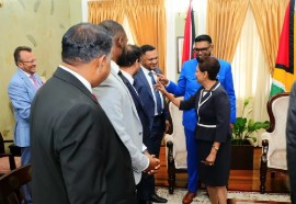 President Irfaan Ali and Prime Minister Kamla Persad-Bissessar share a light moment with ministers of the Guyana delegation during the meeting in Trinidad on Friday.
