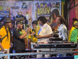 Caption: ⁠Gairy Webb (second from left) of The Ramping Shop Family presents a trophy to Whitfield “Witty” Henry, music producer and promoter of the weekly Uptown Mondays dance, at the August 14th edition of Dancehall Thursday in Kingston, Jamaica. Looking on are Papa Michigan (left), Aubrey Douglas and sound system operator ⁠Beetle Bailey.