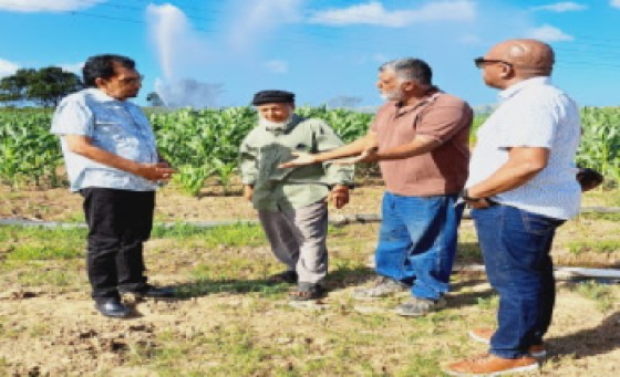Agriculture Minister Kazim Hosein, left, in discussions with rice farmers (Photo Ministry of Agriculture)