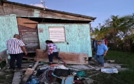 Prime Minister John Briceno in blue shirt, touring damaged areas caused by Hurricane Lisa