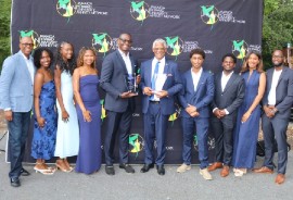 This year’s Jamaica Howard University Affinity Network (JHUAN) IMPACT awardees Trevor Heaven, Chairman of the Board of Directors of Future Energy Source Company Limited (FESCO), and Devon Bryan, co-founder of Cyversity, formerly the International Consortium of Minority Cybersecurity Professionals, center, flank Howard University scholarship recipients at the seventh annual HUes of Blue fundraising reception hosted by the Jamaica Howard University Affinity Network (JHUAN) at Wellspring Manor & Spa in Upper Marlboro, Maryland, on Saturday, September 19, 2026. At extreme left is JHUAN President and Chairman Don Christian. (Derrick Scott Photo