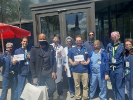 Designer Glenroy March (in black) pose with the frontline workers at Brooklyn Hospital after making the donation