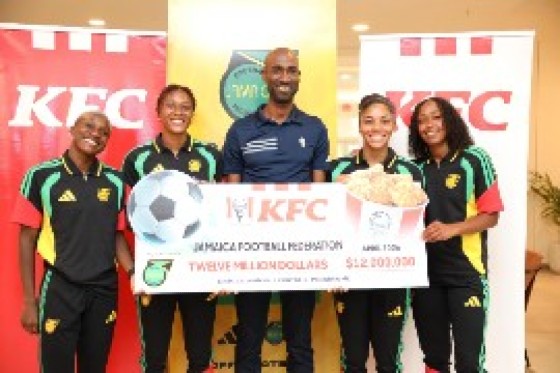 From left: Reggae Girlz defenders Deneisha Blackwood and Allyson Swaby join KFC Jamaica Marketing Manager Andrei Roper, alongside forward Kameron Simmonds and midfielder Atlanta Primus during the cheque handover presentation at the official Reggae Girlz sponsorship announcement at the Courtyard Marriott Hotel.