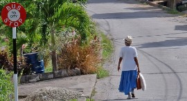 An elderly woman walks through town in Barbados. (PAHO Image)
