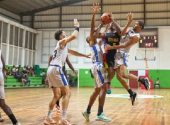 Guyana’s Nikkoli Smith is guarded by three Suriname defenders as he drives to the basket