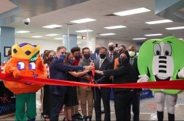 Mascots “Obie” and “Extra Yard” hold the ribbon being cut by (left-to-right) Thomas G. Abraham, chairman of the Anthony R. Abraham Foundation; Kinloch Park Middle Principal Sylvia Coto-Gonzalez, Kinloch Park Middle students, Schools Superintendent Alberto M. Carvalho and School Board member Christi Fraga.