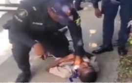 Screen shot of video showing police officer kneeling on the chest of 11-year-old student