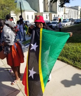 Patron proudly displays St. Kitts and Nevis Flag at Caribbean Themed event in Massachusetts. (Photo credit: Andrew Sharpe)