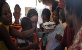 People crowd in for plates of food for their children at a shelter for families displaced by gang violence, in Port-au-Prince, Haiti, March 22, 2024.