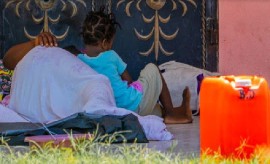 A mother and her child, displaced by gang violence, sleep on the bare floor of a school in Haiti (IOM/Antoine Lemonnier Photo)