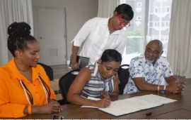 Minister with responsibility for Culture in the Prime Minister’s Office, Dr. Shantal Munro-Knight, signing the MOU while IAAM President, Dr. Tonya Matthews (left); Director of Cultural Policy and Research in the Division of Culture, Dr. Donna Greene-Rusnighi (standing); and Barbados’ Consul General to Miami, Rudy Grant, look on. (BGIS Photo)