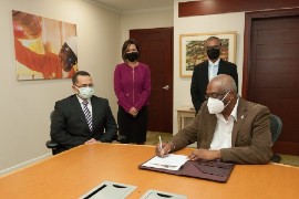 UWI Pro Vice-Chancellor Professor Brian Copeland, signs the agreement commemorating bpTT’s support for first Carbon Capture and Storage (CCS) mapping project. in the presence of UTT and bpTT officials.